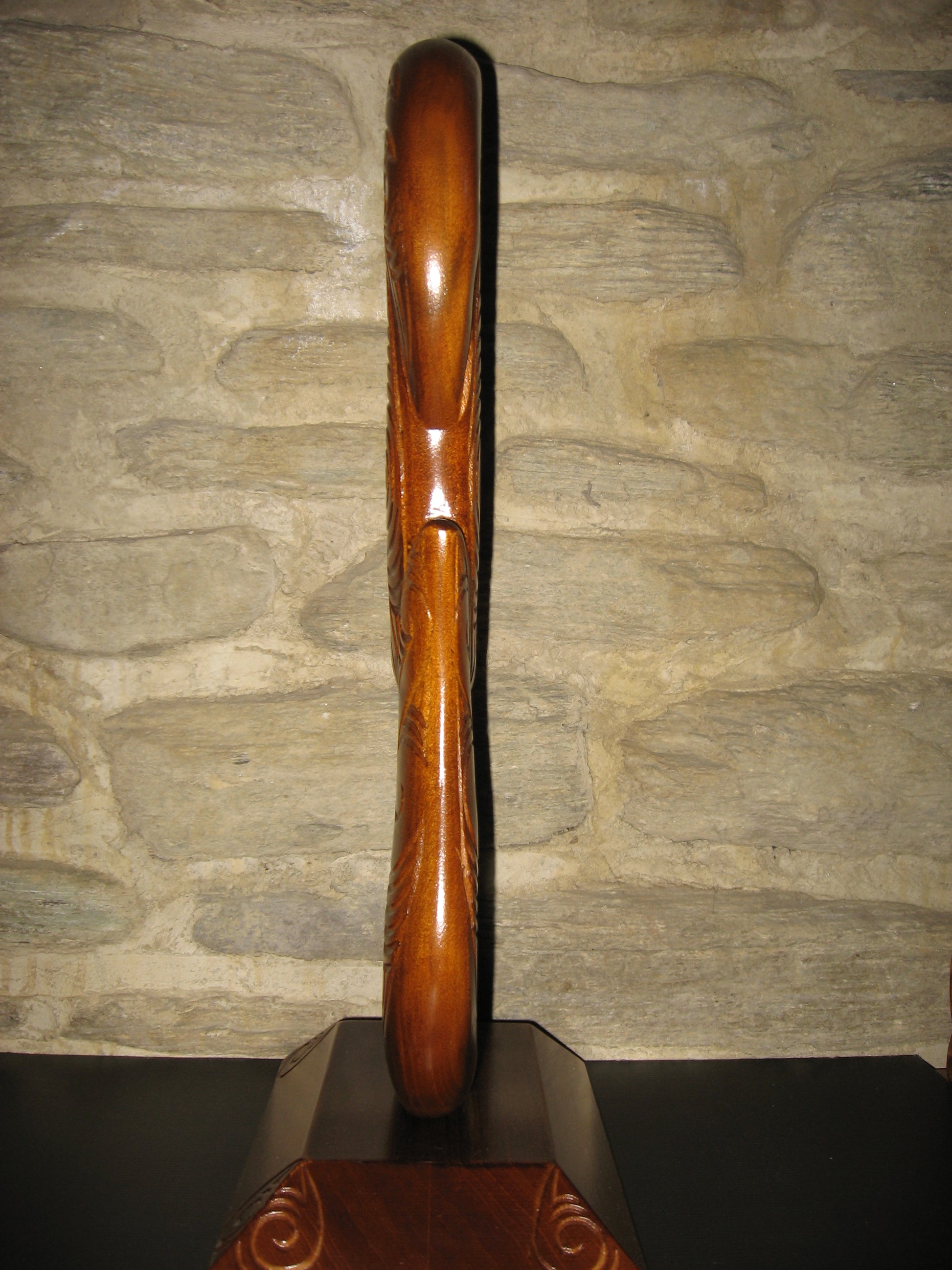 sided view of matau fish hook on base by Wood Masters available from Silver Fern Gallery