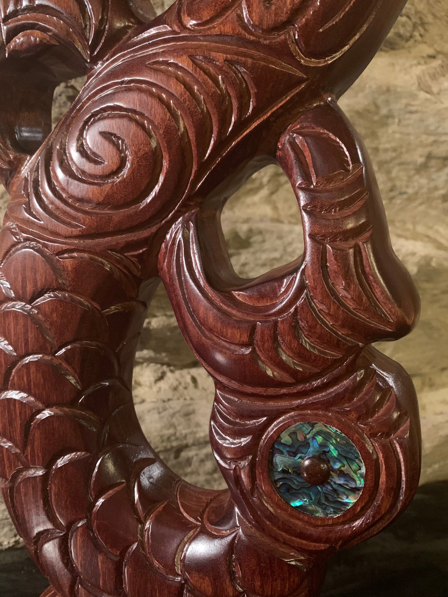 close up of detail in Maori wood manaia on stand carved in New Zealand and available from Silver Fern Gallery